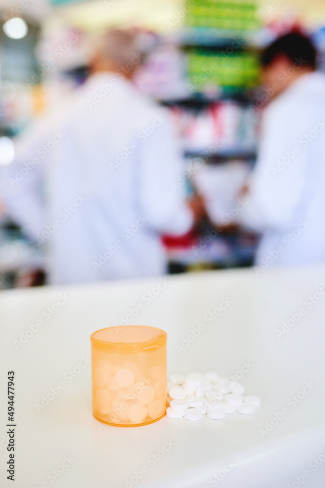 Poster There to help give your health a boost. Shot of a container filed with medication on a counter in a pharmacy.