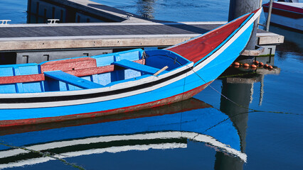 Moliceiro boat with the reflection on water in Ria de Aveiro, San Jacinto, Portugal