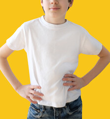 young european child wearing a white t-shirt and blue jeans, boy 9-11 years old on a colored...