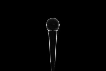 Silhouette of metal microphone on black background. Minimalism.