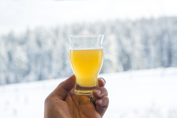 Shallow focus of a Craft Beer Tasting Glass Golden Ale held in a hand With Snow Background