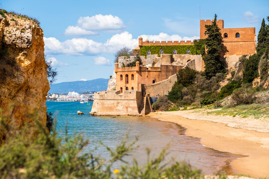 Coastline with sandy beach and castle in Ferragudo, Algarve, Portugal