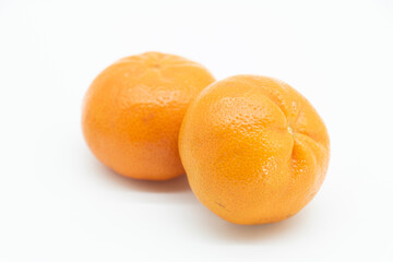 Tangerines or clementines with green leaf on white background