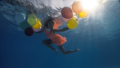 Underwater shoot of flying  woman with multicolored balloons © Oleg