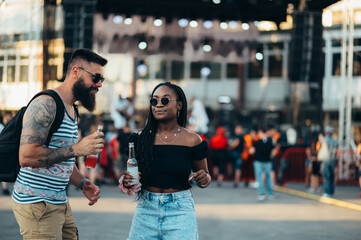 Beautiful couple drinking cocktails and having fun at music festival