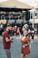 Beautiful couple drinking cocktails and having fun at music festival