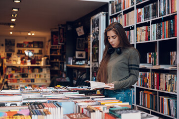 Woman buying books at a bookstore - Powered by Adobe