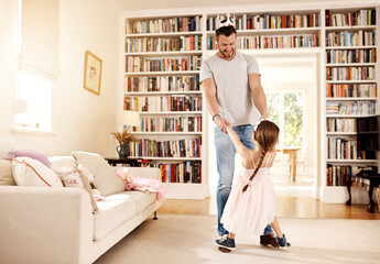Can I have this dance with you. Shot of a father dancing with his little daughter at home.