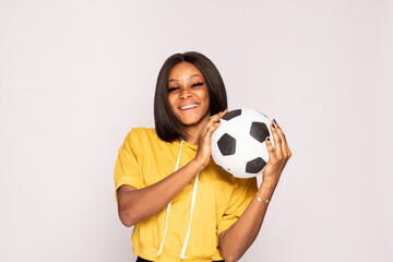 excited young black woman holding a football