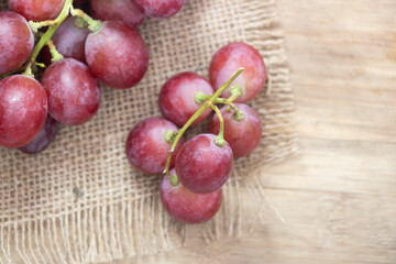 Red grape isolated on wooden background.top view