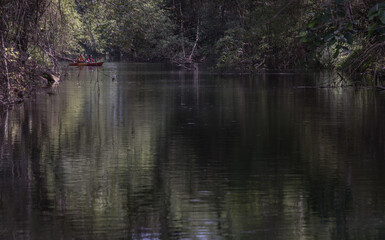 Nakhon Ratchasima, Thailand. Mar - 20, 2022 : Two young woman adventurous people having fun together while red kayaking on brook in forest. Having fun in leisure activity, Nature and Tourist attractio