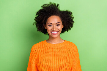 Photo of optimistic millennial volume hairdo lady wear orange sweater isolated on green color background