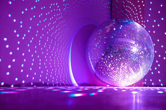 Disco ball reflecting purple light. Holidays concept. Copy space.	
