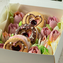 gift set of handmade sweet flowers, donuts with jam and marshmallow flowers in a white box.