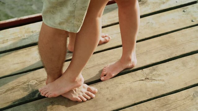 Close-up of couple's foot standing on the wood floor