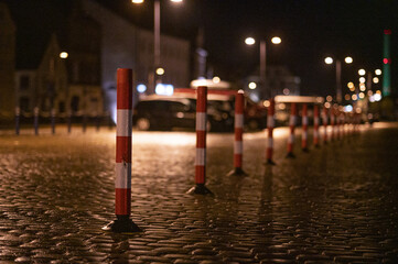 Closeup shot of roadblocks in the street at the night - obrazy, fototapety, plakaty