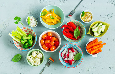 Fresh, raw, sliced vegetables in a colorful bowls. Healthy party snacks - vegetarian or vegan diet.