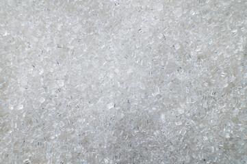 Macro shot of white sugar closeup on the surface as an abstract background. Food industry benefits and harms of granulated sugar