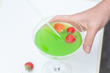 Colorful bright green cocktail cactus with strawberries, delicious refreshing