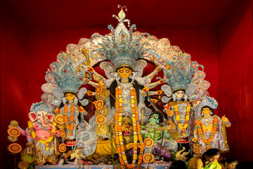 Goddess Durga idol at decorated Durga Puja pandal, shot at colored light, at Kolkata, West Bengal, India. Durga Puja is biggest religious festival of Hinduism and is now celebrated worldwide. - obrazy, fototapety, plakaty
