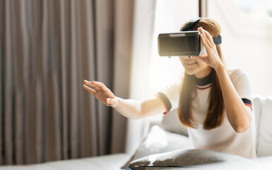 Woman in VR glasses. Confident young woman in virtual reality headset pointing in the air while...