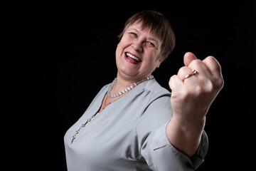 An elderly woman shows her fist to you.