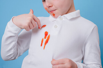 Close up stain tomato sauce spilled on children's outfit. The concept of cleaning stains on clothes