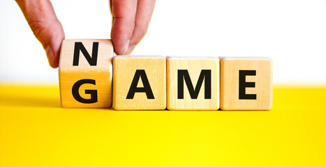 Name of the game symbol. Wooden blocks with concept words Name Game. Businessman hand. Beautiful yellow table white background. Business and name of the game concept. Copy space.