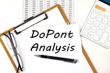Text DUPON ANALYSIS on the white paper on clipboard with chart and calculator