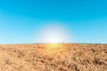 Beautiful agricultural rural sunset background,spring landscape.Blue clear sky background. Plowed field in the foreground.Copy space.
