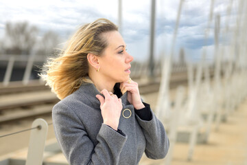 Stylish woman standing in a platform on a breezy day