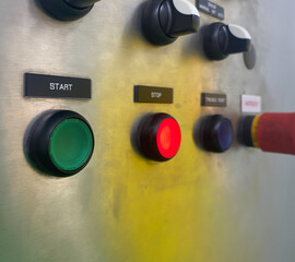 Shallow depth of field, push-button start switch has a green light. with a red light stop button mounted on stainless steel cabinet