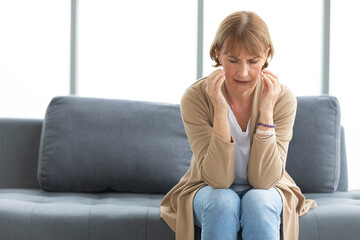 Obraz premium senior woman have a headache on a sofa