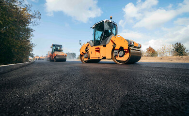 Vibratory asphalt rollers compactor compacting new asphalt pavement. Road service build a new highway	
