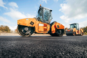 Vibratory asphalt rollers compactor compacting new asphalt pavement. Road service build a new highway	
