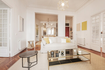 Vacation rental living room with light fabric sofa, stained-glass wood doors, rectangular coffee table, and large light-colored rug on wooden deck