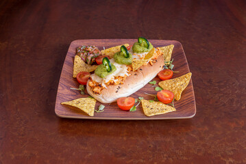 Mexican-style chicken sandwich with guacamole, jalapeños, pico de galle and corn chips with half cherry tomatoes