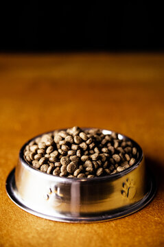 Metal bowl with dry food placed on floor