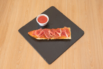 Serrano ham toast, brie cheese and tomato jam fresh from the oven. To complete a perfect dinner,