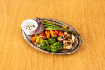 Grilled vegetable tray with wild asparagus, broccoli, red onion, peppers, tomatoes and sliced mushrooms