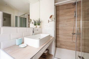Bathroom with white porcelain sink with mirror, white tiles and walk-in shower
