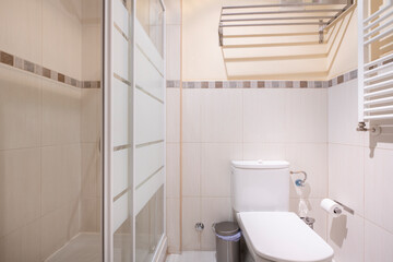 Bathroom with white towel-drying radiator and shower cabin with white details