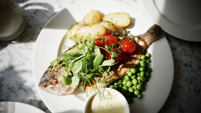 Closeup shot of a grilled frish with fresh vegetables