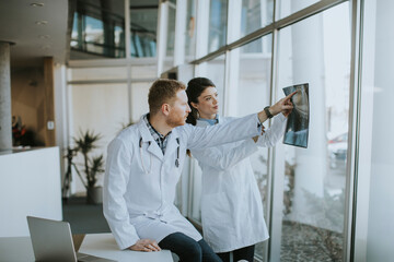 Team of young doctors examining x-ray image in the office