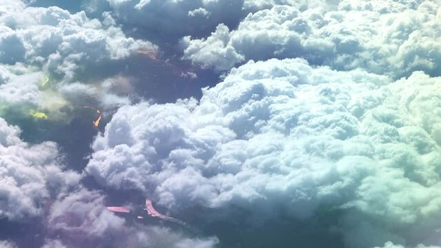 View from the airplane window to the wing. Good weather outside. Clouds in the sky. View from the porthole of the plane to the ground. Flying above the clouds high in the sky. The passenger looks out