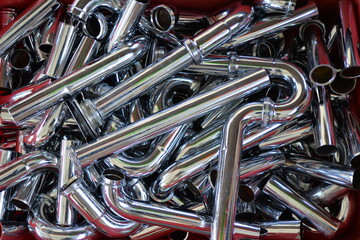 A heap of new chrome sewages tubes in a box on flea market in Berlin-City. 