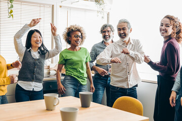 Young multiracial people having fun dancing in the kitchen - Focus on african girl face