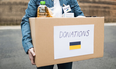 Volunteer collecting box with donations for Ukrainian refugees - Humanitarian aid for Ukraine