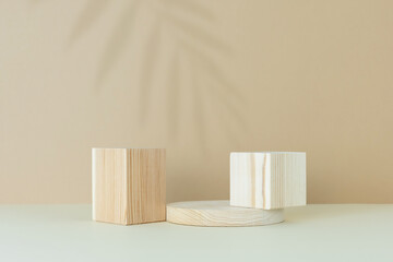 Wooden scenes with a shadow of tropical palm leaves on a light table against a beige wall background. Premium podium for advertising your product. Background for the product presentation.