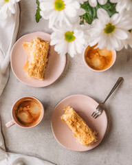 cup of coffee and piece of Napoleon Cake and white flowers